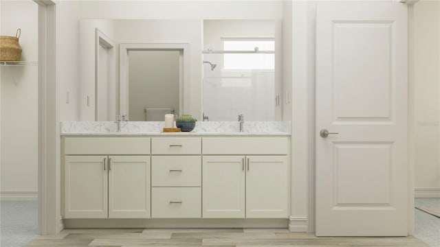 7546 E 117th Ln, Palmetto, FL 34221 - bathroom featuring double vanity, a stall shower, and wood finished floors