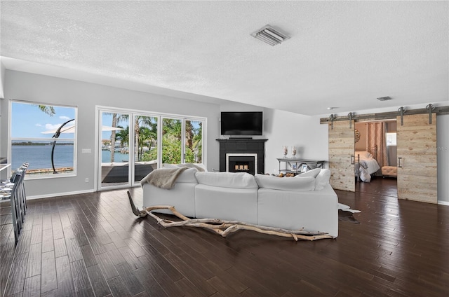 511 Island Way, Clearwater Beach, FL 33767 - living area featuring a barn door, a textured ceiling, wood finished floors, and a fireplace