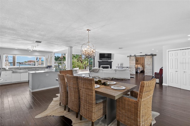 511 Island Way, Clearwater Beach, FL 33767 - dining area featuring a barn door, dark wood finished floors, a chandelier, a textured ceiling, and recessed lighting