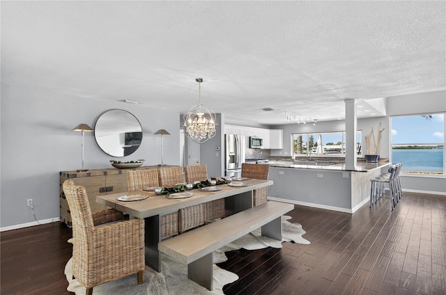 511 Island Way, Clearwater Beach, FL 33767 - dining space with dark wood-style floors, a chandelier, and a textured ceiling