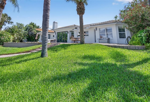 511 Island Way, Clearwater Beach, FL 33767 - back of house featuring stucco siding and a yard