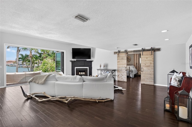 511 Island Way, Clearwater Beach, FL 33767 - living area with a barn door, wood finished floors, a textured ceiling, a fireplace, and recessed lighting