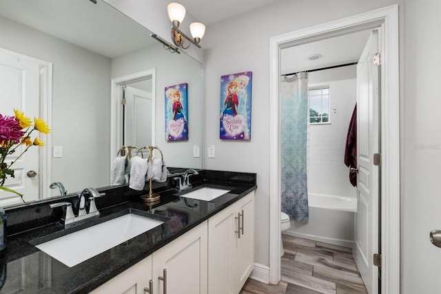 4301 5th Ave N, Saint Petersburg, FL 33713 - bathroom with double vanity, toilet, shower / bath combo with shower curtain, and wood finished floors