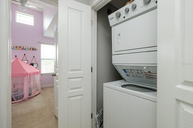 4301 5th Ave N, Saint Petersburg, FL 33713 - laundry room featuring stacked washing machine and dryer, plenty of natural light, and light colored carpet