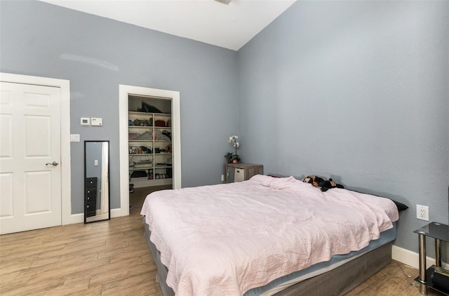 629 Orange Valley Ln, Lakeland, FL 33813 - bedroom with light wood finished floors, a closet, a spacious closet, baseboards, and vaulted ceiling
