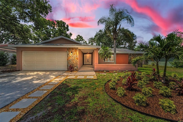 2063 Ridgecrest Dr, Dunedin, FL 34698 - view of front of property featuring concrete driveway, a garage, stone siding, and a front lawn