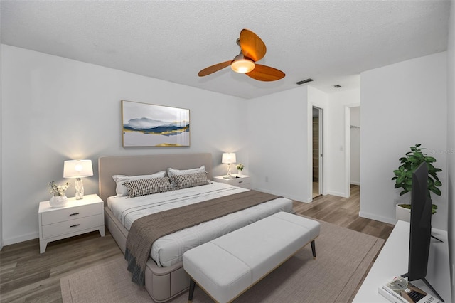 2063 Ridgecrest Dr, Dunedin, FL 34698 - bedroom featuring wood finished floors, baseboards, a ceiling fan, and a textured ceiling