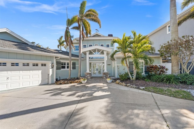 17077 Dolphin Dr, North Redington Beach, FL 33708 - view of front of house with french doors, board and batten siding, concrete driveway, and a garage