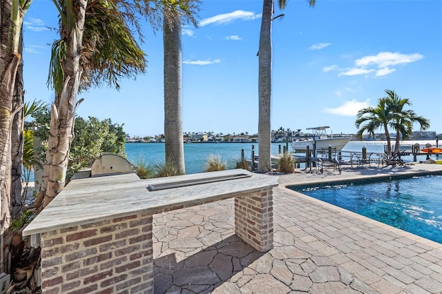 17077 Dolphin Dr, North Redington Beach, FL 33708 - swimming pool with an outdoor kitchen, a patio area, a water view, and exterior bar