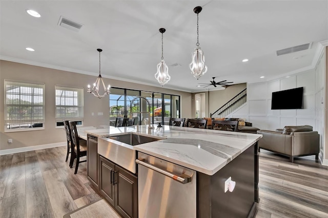 9136 Warm Springs Cir, Parrish, FL 34219 - kitchen with stainless steel dishwasher, a chandelier, a sink, crown molding, and pendant lighting