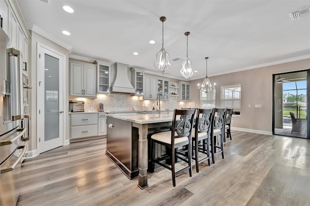 9136 Warm Springs Cir, Parrish, FL 34219 - kitchen featuring premium range hood, a chandelier, decorative backsplash, light countertops, and baseboards