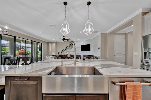 9136 Warm Springs Cir, Parrish, FL 34219 - kitchen featuring appliances with stainless steel finishes, a chandelier, open floor plan, a sink, and hanging light fixtures