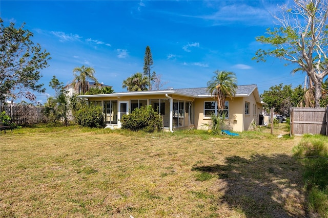 11465 7th St E, Treasure Island, FL 33706 - rear view of house featuring a sunroom and stucco siding