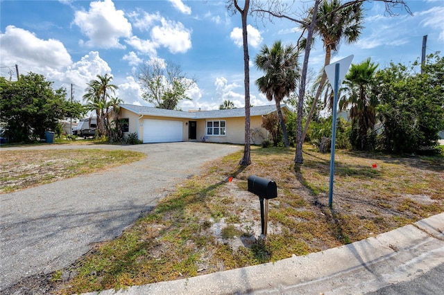 11465 7th St E, Treasure Island, FL 33706 - ranch-style home featuring a garage, driveway, and stucco siding