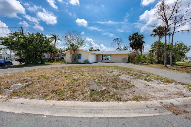 11465 7th St E, Treasure Island, FL 33706 - ranch-style house with a garage, curved driveway, and stucco siding