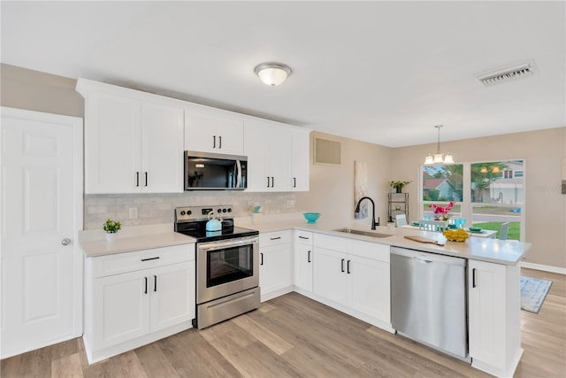 704 Childers Loop, Brandon, FL 33511 - kitchen featuring stainless steel appliances, a sink, a peninsula, and light wood-type flooring