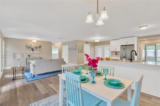 704 Childers Loop, Brandon, FL 33511 - dining area with light wood-style floors, a chandelier, baseboards, and french doors