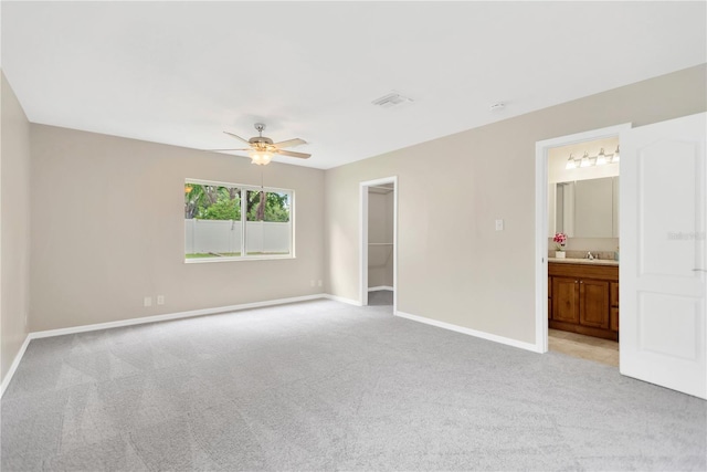 704 Childers Loop, Brandon, FL 33511 - unfurnished bedroom featuring light colored carpet, baseboards, a walk in closet, and ensuite bath