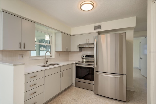 2020 Douglas Ave, Dunedin, FL 34698 - kitchen featuring stainless steel appliances, a sink, under cabinet range hood, tasteful backsplash, and light countertops