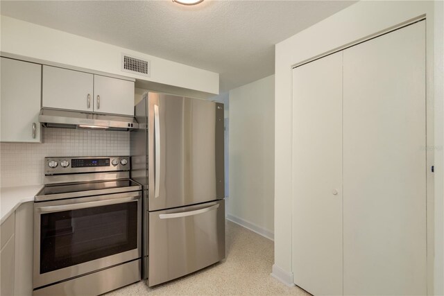 2020 Douglas Ave, Dunedin, FL 34698 - kitchen featuring appliances with stainless steel finishes, under cabinet range hood, light countertops, tasteful backsplash, and white cabinets