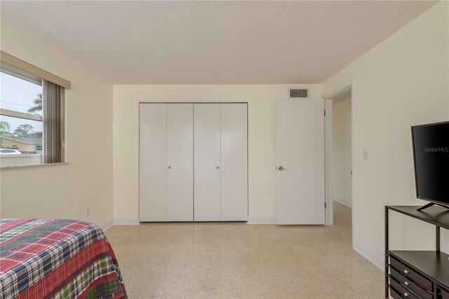 2020 Douglas Ave, Dunedin, FL 34698 - bedroom with baseboards, a closet, and a textured ceiling