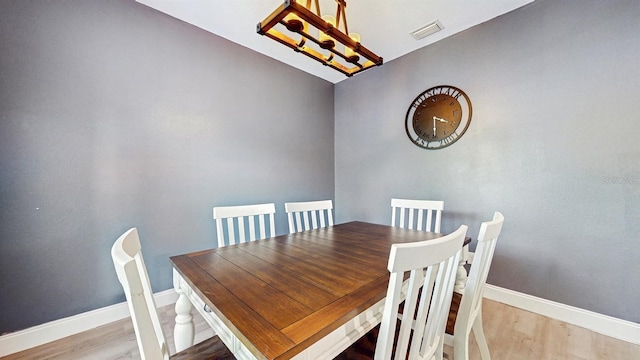 8111 Brickleton Woods Ave, Gibsonton, FL 33534 - dining area featuring wood finished floors, baseboards, and a chandelier