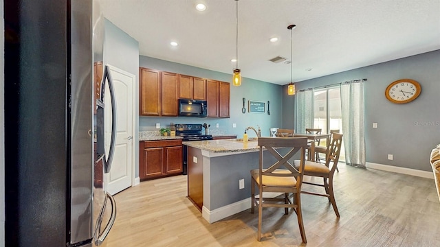 8111 Brickleton Woods Ave, Gibsonton, FL 33534 - kitchen featuring black appliances, light wood-type flooring, brown cabinetry, a sink, and recessed lighting