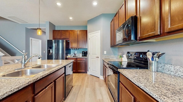 8111 Brickleton Woods Ave, Gibsonton, FL 33534 - kitchen with black appliances, a sink, light wood-style floors, pendant lighting, and brown cabinetry