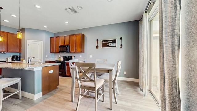 8111 Brickleton Woods Ave, Gibsonton, FL 33534 - kitchen with black appliances, a sink, light wood-type flooring, light stone counters, and recessed lighting