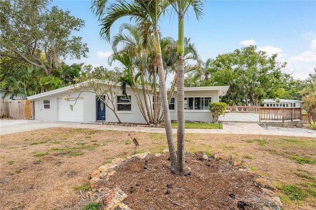 12 Bayou Ln, Palm Harbor, FL 34683 - view of front facade with concrete driveway, a garage, a deck, and stucco siding