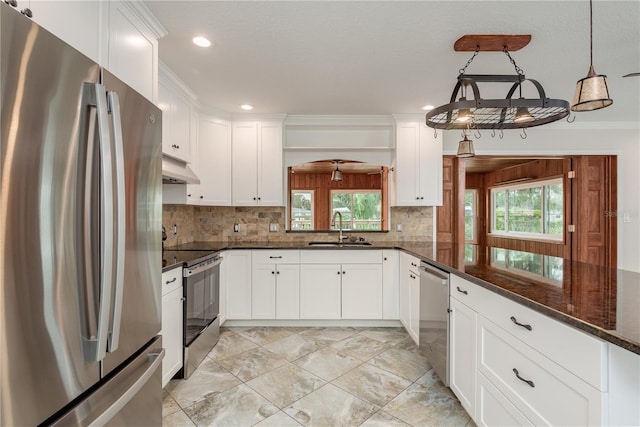 12 Bayou Ln, Palm Harbor, FL 34683 - kitchen featuring appliances with stainless steel finishes, under cabinet range hood, white cabinets, tasteful backsplash, and recessed lighting