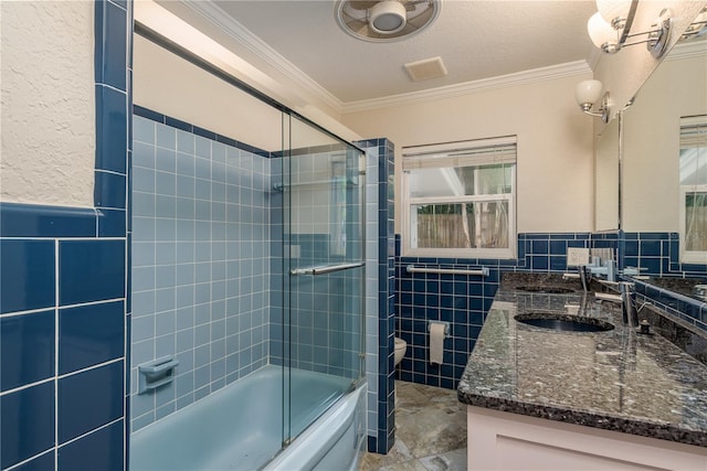 12 Bayou Ln, Palm Harbor, FL 34683 - full bathroom with tile walls, double vanity, ornamental molding, enclosed tub / shower combo, and wainscoting