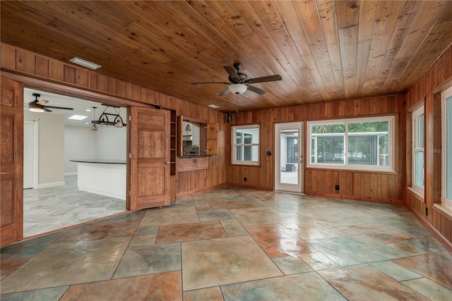 12 Bayou Ln, Palm Harbor, FL 34683 - empty room with ceiling fan, wooden walls, wood ceiling, and stone finish flooring