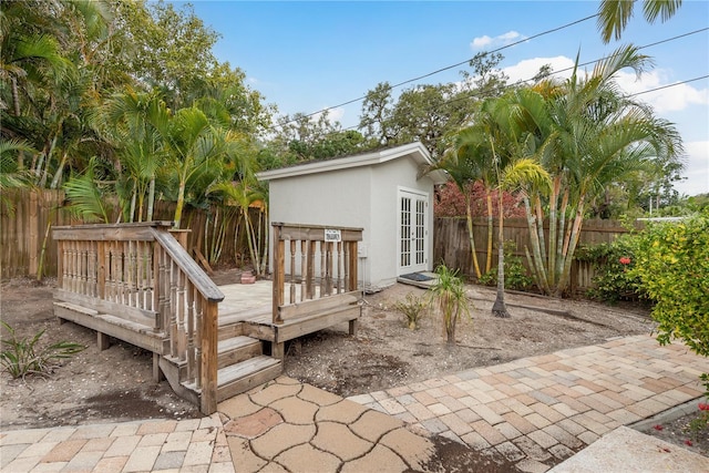12 Bayou Ln, Palm Harbor, FL 34683 - fenced backyard featuring french doors, a deck, and an outdoor structure