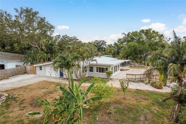 12 Bayou Ln, Palm Harbor, FL 34683 - back of house with a wooden deck, concrete driveway, and stucco siding