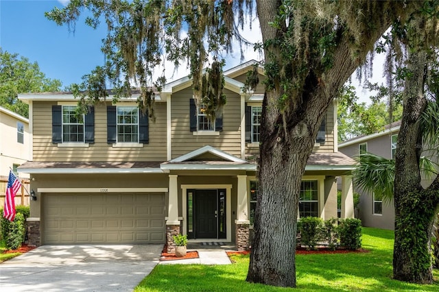 12208 Mcmullen Loop, Riverview, FL 33569 - view of front facade featuring a garage, stone siding, concrete driveway, a front lawn, and stucco siding