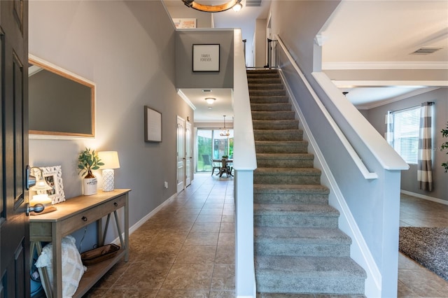 12208 Mcmullen Loop, Riverview, FL 33569 - staircase with crown molding, tile patterned flooring, baseboards, and a chandelier