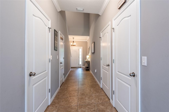 12208 Mcmullen Loop, Riverview, FL 33569 - corridor featuring ornamental molding, tile patterned flooring, a textured ceiling, and baseboards