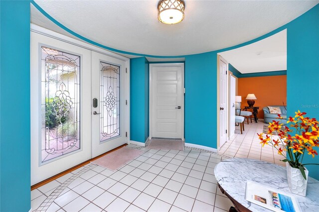 2096 Massachusetts Ave NE, Saint Petersburg, FL 33703 - entrance foyer with light tile patterned floors, baseboards, and french doors