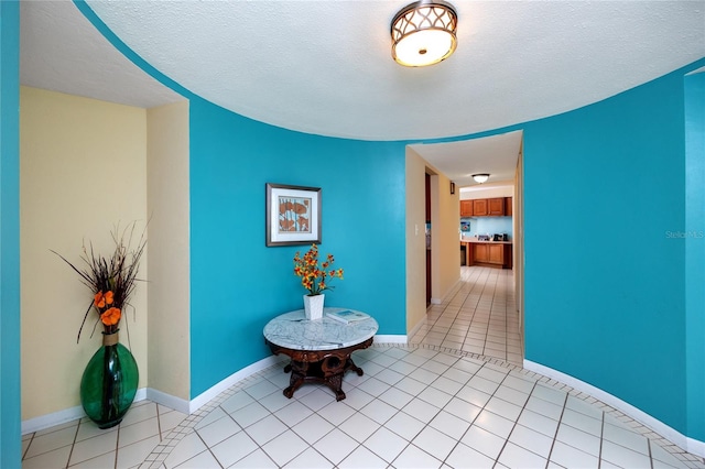 2096 Massachusetts Ave NE, Saint Petersburg, FL 33703 - corridor featuring baseboards, a textured ceiling, and light tile patterned floors