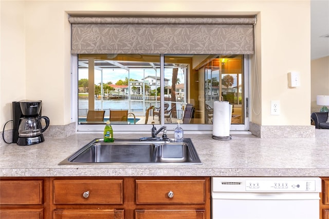 2096 Massachusetts Ave NE, Saint Petersburg, FL 33703 - kitchen with white dishwasher, a sink, light countertops, and brown cabinetry