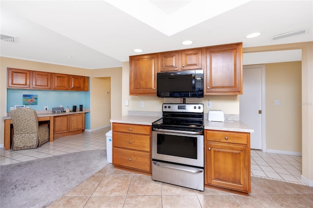 2096 Massachusetts Ave NE, Saint Petersburg, FL 33703 - kitchen with black microwave, stainless steel electric range oven, light tile patterned flooring, light countertops, and recessed lighting