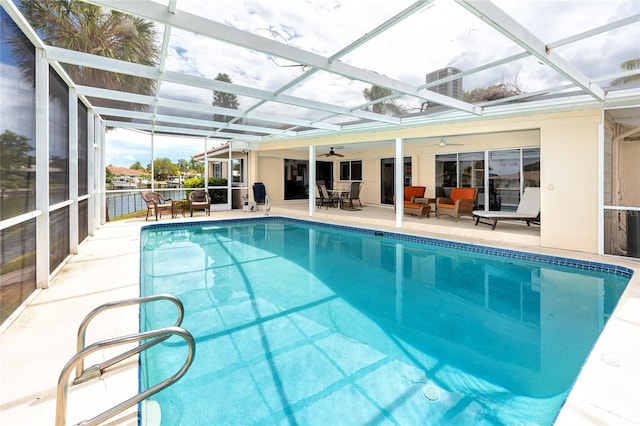 2096 Massachusetts Ave NE, Saint Petersburg, FL 33703 - swimming pool with ceiling fan, a patio, an outdoor hangout area, and glass enclosure