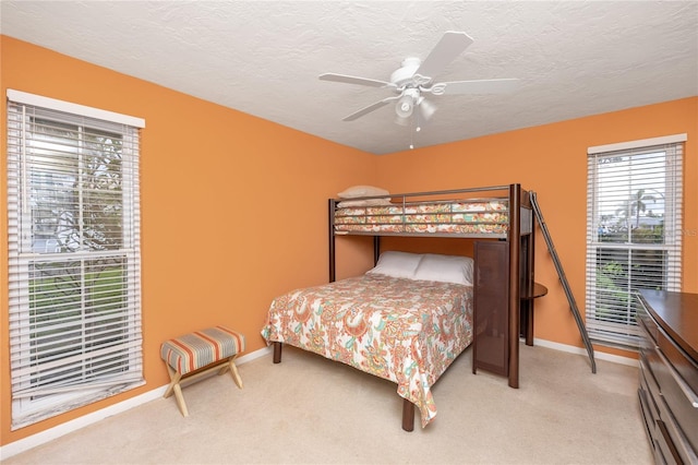 2096 Massachusetts Ave NE, Saint Petersburg, FL 33703 - bedroom with baseboards, light colored carpet, a textured ceiling, and a ceiling fan