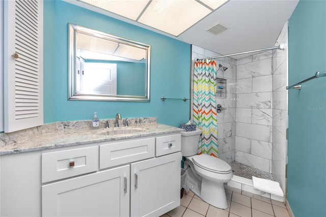 2096 Massachusetts Ave NE, Saint Petersburg, FL 33703 - bathroom with toilet, a tile shower, vanity, and tile patterned floors
