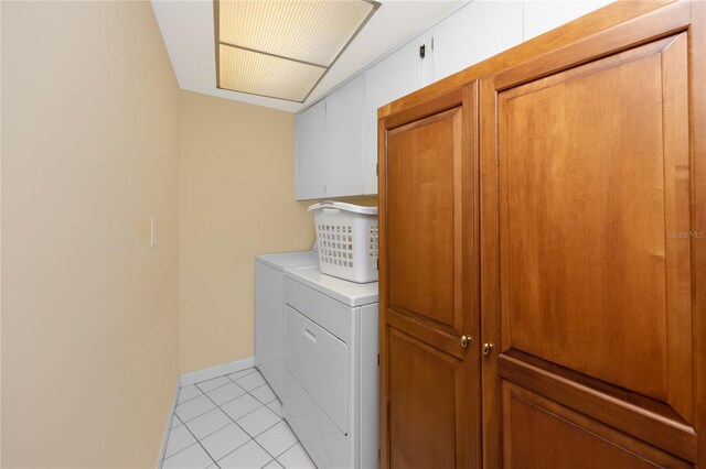 2096 Massachusetts Ave NE, Saint Petersburg, FL 33703 - washroom featuring independent washer and dryer, cabinet space, light tile patterned floors, and baseboards