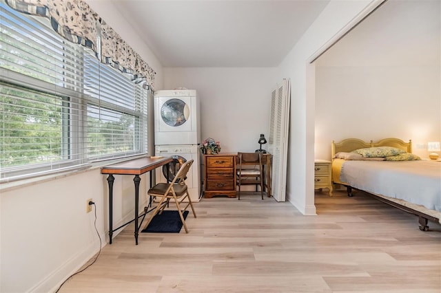 4748 Azalea Dr Unit 204, New Port Richey, FL 34652 - bedroom featuring stacked washer and clothes dryer, light wood finished floors, a closet, and baseboards