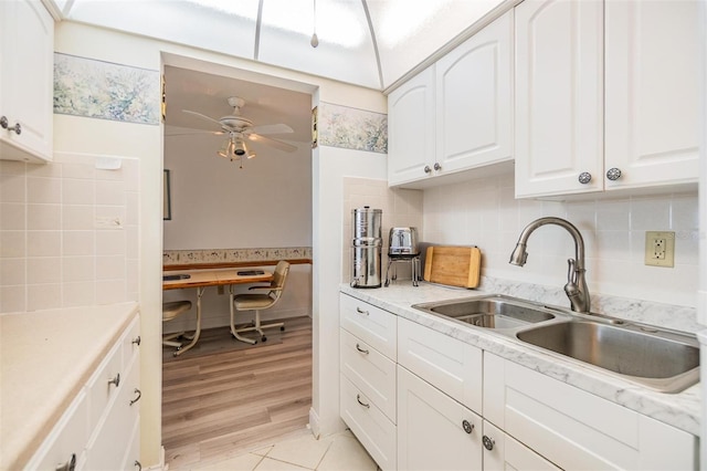4748 Azalea Dr Unit 204, New Port Richey, FL 34652 - kitchen featuring a sink, a ceiling fan, white cabinets, and decorative backsplash
