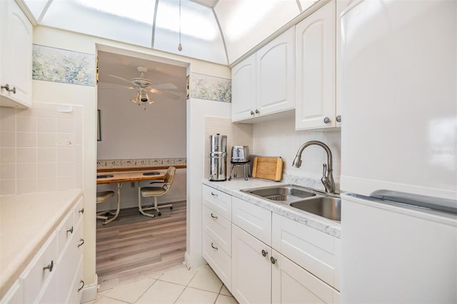 4748 Azalea Dr Unit 204, New Port Richey, FL 34652 - kitchen featuring freestanding refrigerator, a sink, white cabinetry, a ceiling fan, and backsplash