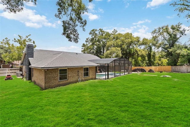 722 Swaying Palm Dr, Apopka, FL 32712 - back of house featuring a fenced backyard, roof with shingles, a lanai, a chimney, and brick siding